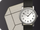 Reloj minimalista en correa de cuero negro, con cara blanca que destaca por su claridad y sencillez.